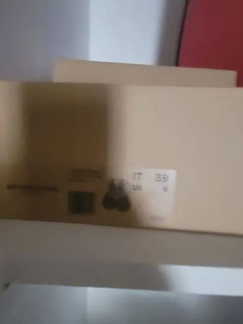 A cardboard carton photographed while moving, too blurred to read its printed label